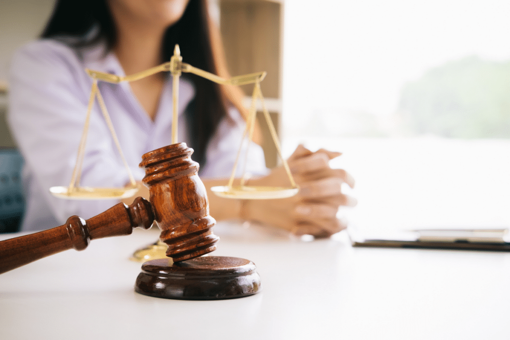 gavel and scales of justice on a desk with a person in the background