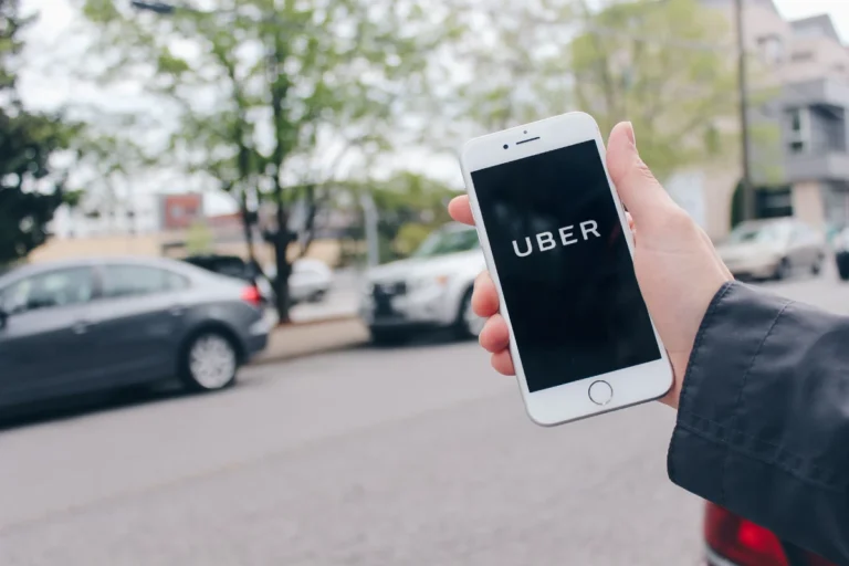 A man holding a phone with opened Uber account