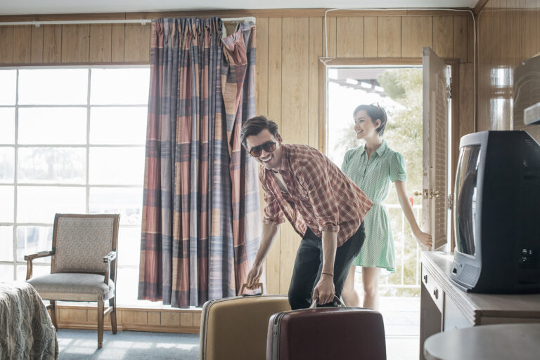 A young couple arriving in a motel room.