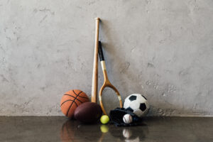 Close-up photograph of sports equipment including a basketball, soccer ball, and tennis balls