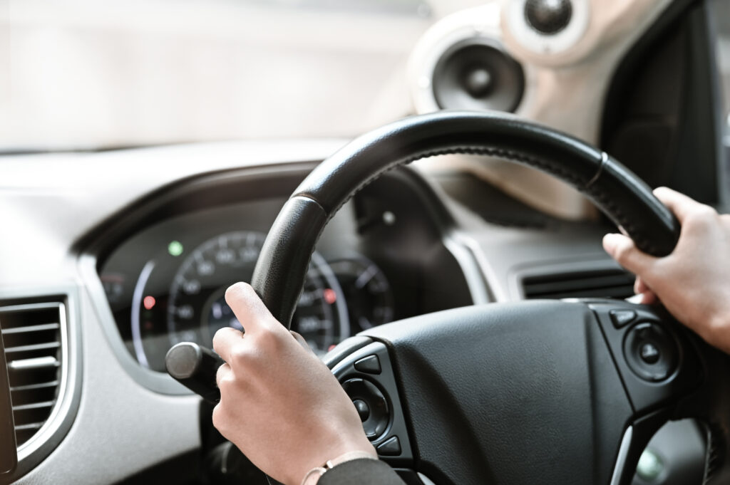 a close-up view of an uber driver's hands gripping the steering wheel of his car