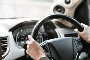 a close-up view of an uber driver's hands gripping the steering wheel of his car