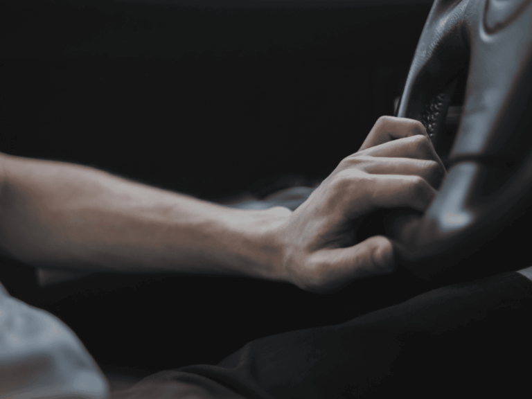close-up of a man's hand gripping the steering wheel