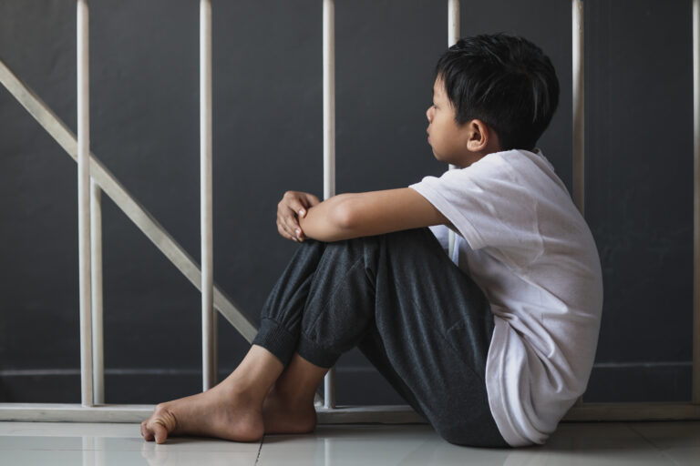 youth in Oregon juvenile detention center crouched against bars