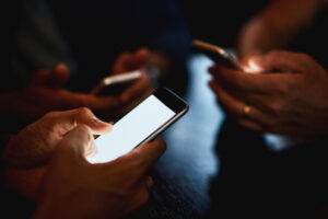 Group of people sitting at a table together on their cell phones