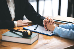 Attorney placing hand on client supportively after the awarding of a settlement.