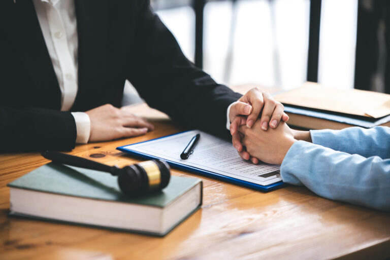 Attorney placing hand on client supportively after the awarding of a settlement.