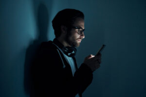 Young man using smart phone in the dark