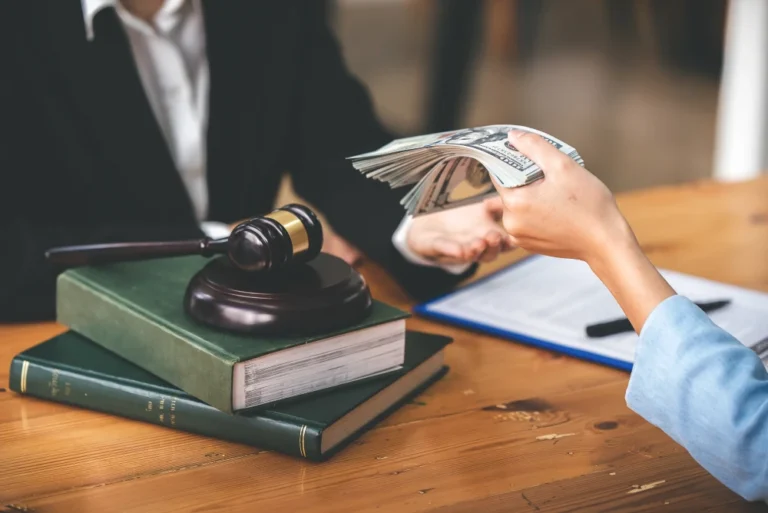 Client handing a stack of cash to a juvenile detention sex abuse lawyer while sitting at a desk