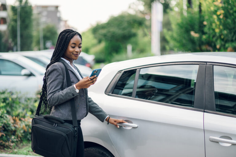 African american business woman getting into the car and using s