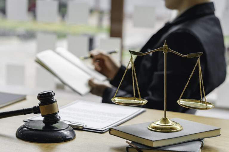 Judge sitting at the desk, holding and reading a book