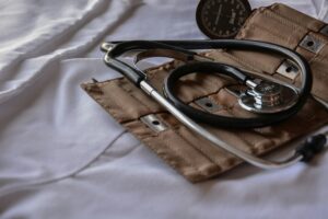 Doctor's kit with stethoscope open on a hospital bed