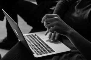 Black and white photo of a parent creating child safe accounts on Roblox on a computer