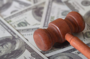 Wooden gavel of justice on top of pile of US dollar bills