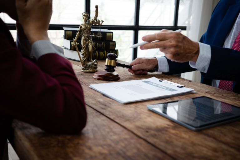 Lawyer and client discussing important legal documents for justice with gavel on desk