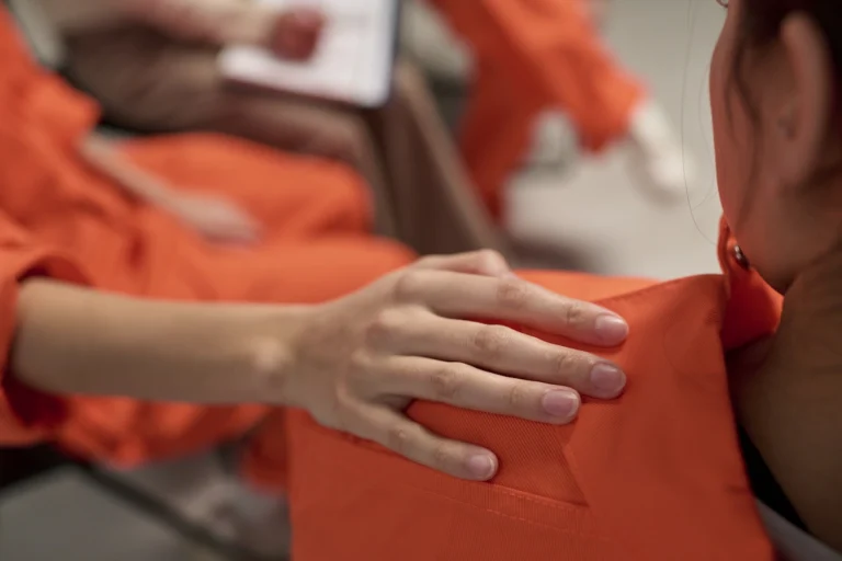 Young Adult Woman Comforting Another Inmate during Prison Therapy Session